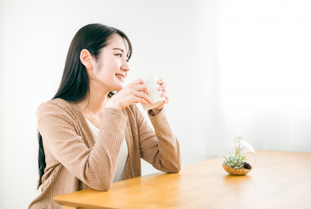 コーヒーを飲んでくつろいでいる女性