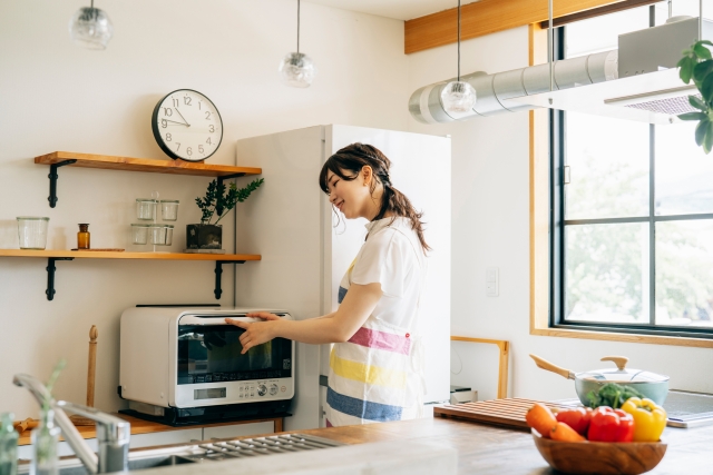 電子レンジを使っている女性
