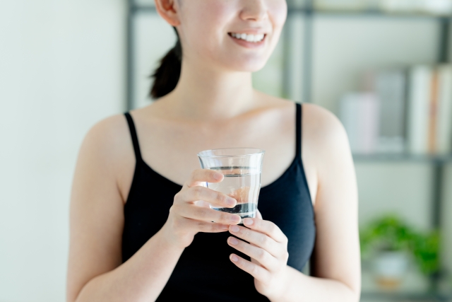 水の入ったコップを持った女性