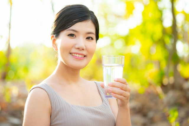 水の入ったコップを持っている女性